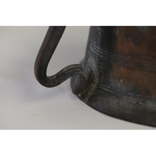 18 - An antique Middle Eastern bath pitcher made of bronze or copper, featuring a flared base, a wavy top... 