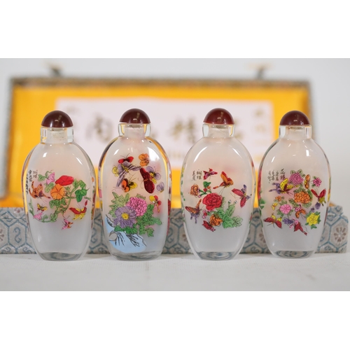 73 - **Set of Four 20th-Century Chinese Reverse-Painted Scent Bottles in Decorative Case**  This elegant ... 