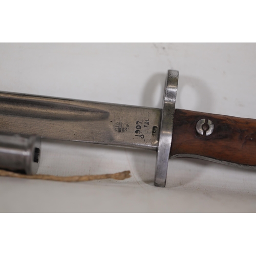 855 - 1907 Lee-Enfield Bayonet with Leather Scabbard  This 1907 Lee-Enfield bayonet, measuring 22.5 inches... 