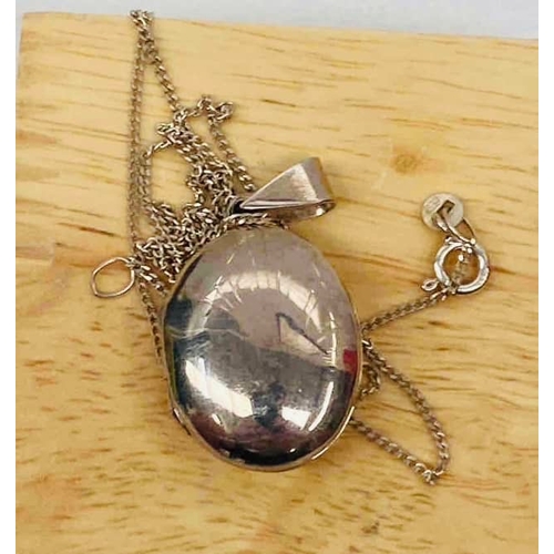 34 - Sterling silver locket necklace. Oval-shaped pendant stamped 