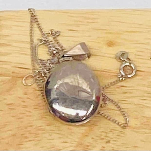 34 - Sterling silver locket necklace. Oval-shaped pendant stamped 