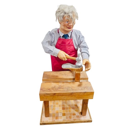 13 - A working automaton figure display of a cobbler, with grey hair, articulated arms holding hammer and... 