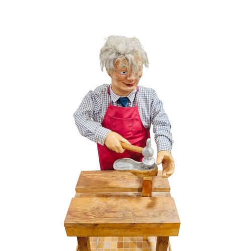 13 - A working automaton figure display of a cobbler, with grey hair, articulated arms holding hammer and... 