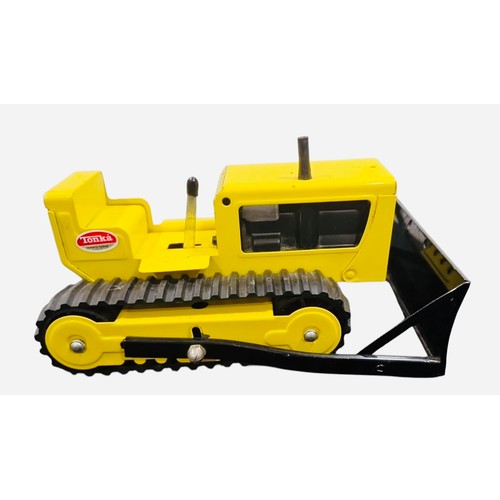 23C - A Tonka pressed-metal toy tracked bulldozer, in yellow and black with rubber tracks, front blade, gl... 