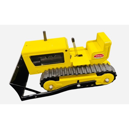 23C - A Tonka pressed-metal toy tracked bulldozer, in yellow and black with rubber tracks, front blade, gl... 
