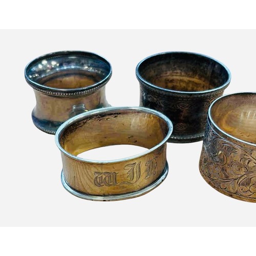 46 - A group of four sterling silver napkin rings, three engraved and one with foliate chasing, including... 