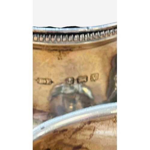 46 - A group of four sterling silver napkin rings, three engraved and one with foliate chasing, including... 