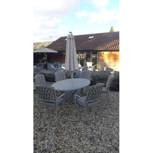 81 - A Bramblecrest Rome elliptical table with six armchairs with cushions, parasol and base