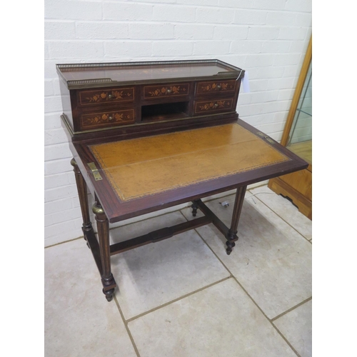 296 - A 19th century inlaid rosewood bonheur de jour with a brass gallery on five drawer upstand with a fo... 