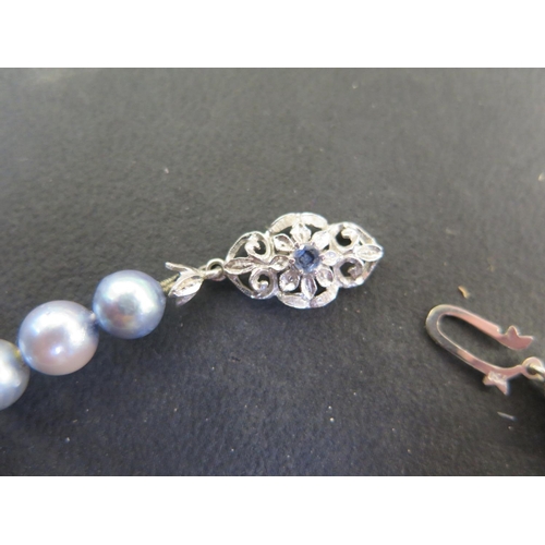 907 - A coloured pearl necklace with earrings, the clasp marked 750, 49cm long, pearls approx 6mm diameter