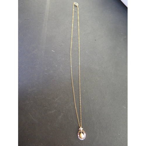 906 - A 9ct yellow gold pearl pendant on a gilt chain, possibly 9ct - total weight approx 1.6 grams