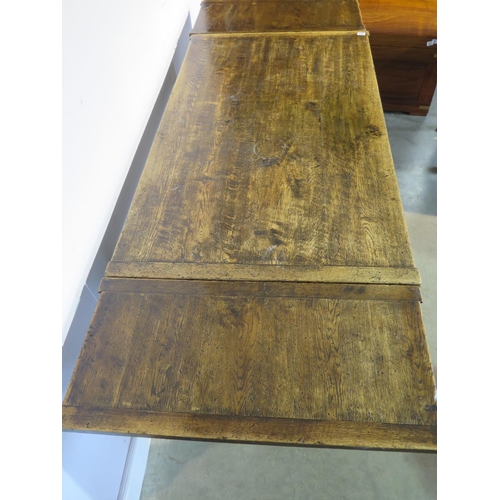 254 - An 18th century style oak draw leaf table on turned legs with a carved frieze - Height 77cm x 128cm ... 