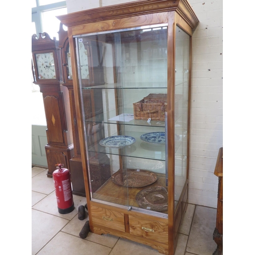 299 - A good quality modern oak shop display cabinet with three internal shelves, two sliding lockable doo... 