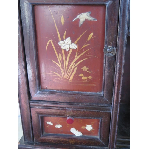 314 - An Oriental table cabinet with fretwork decoration with three lacquer decorated doors and a drawer -... 