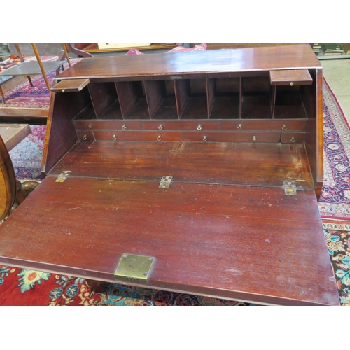 323 - A Georgian mahogany kneehole bureau with a fitted interior of candle slides, drawers and pigeon hole... 