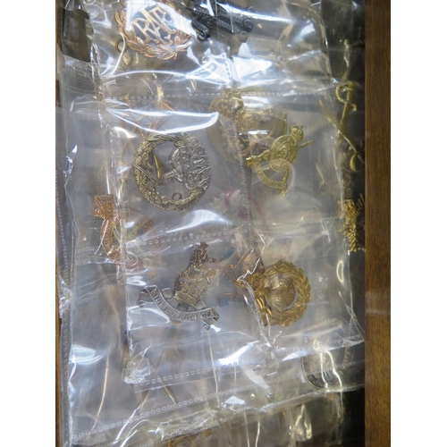 562 - A large quantity of Regimental cap badges and Insignia, buttons and cloth badges, tea cards, cigaret... 