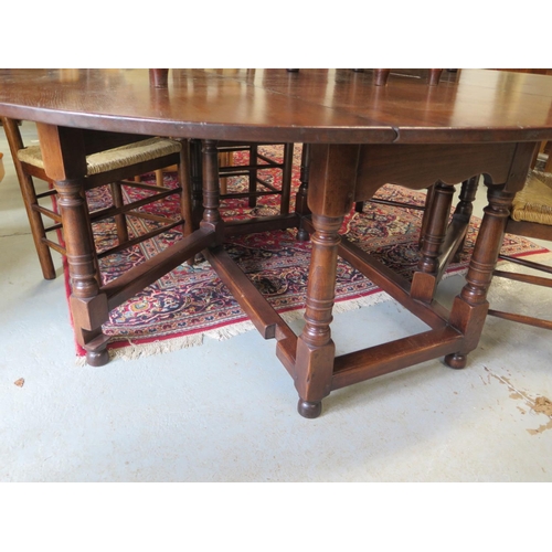 69 - An antique style oak gate leg table with 8 ladder back chairs including two carvers with rush seats ... 