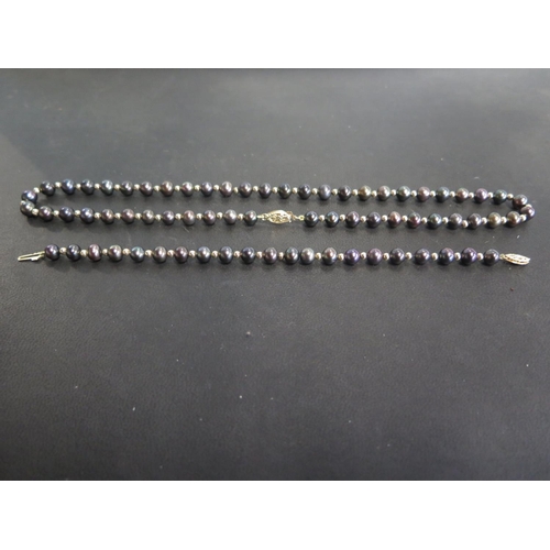 759 - A black pearl necklace and matching bracelet - 44cm and 19cm respectively - in good condition