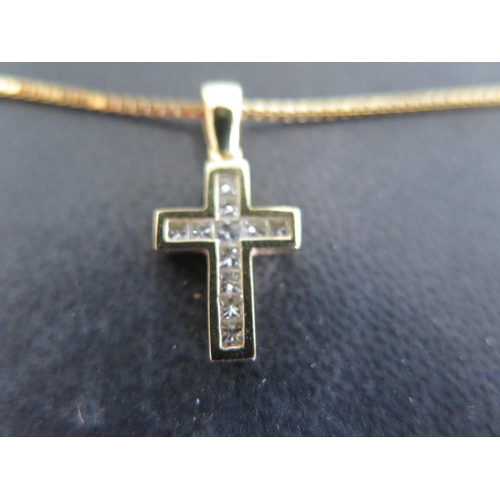 777 - An 18ct yellow gold crucifix studded with diamond chips on an 18ct yellow gold chain - approx length... 