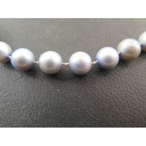 907 - A coloured pearl necklace with earrings, the clasp marked 750, 49cm long, pearls approx 6mm diameter