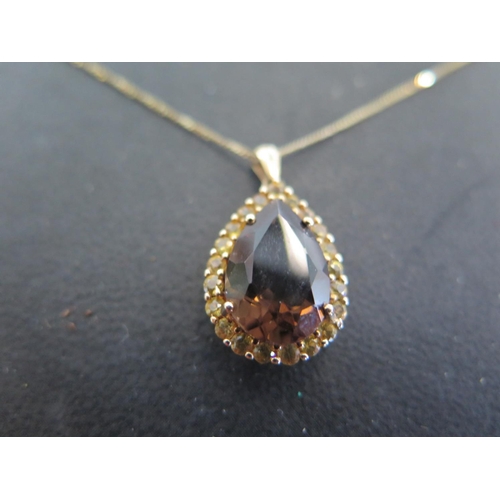 948 - A 9ct gold smokey quartz and yellow sapphire set pendant - chain length approx 45cm - total weight a... 