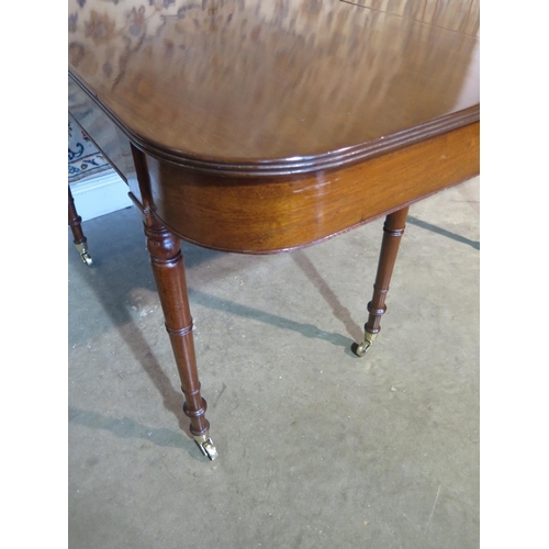 395 - A William IV mahogany dining table with additional leaf, turned legs and brass casters, approximatel... 