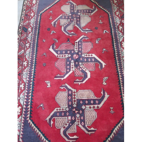 478 - A hand knotted woollen rug with a blue field and geometric design - 143cm x 290cm approx