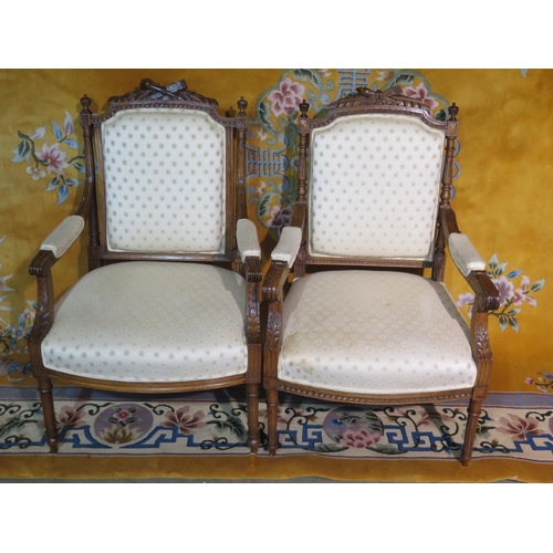 233 - A near pair of carved walnut upholstered open armchairs with scroll arms, some small fabric wear sta... 