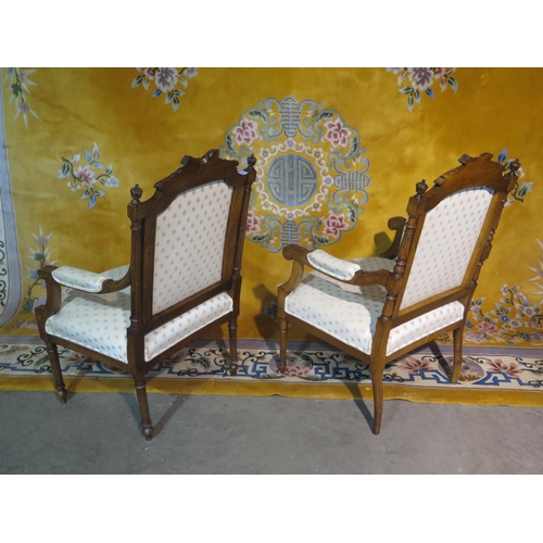 233 - A near pair of carved walnut upholstered open armchairs with scroll arms, some small fabric wear sta... 