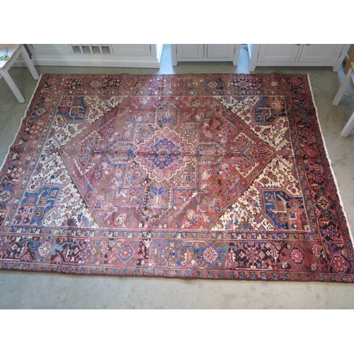 482 - A hand knotted, woollen Heriz rug with red ground, approx. 291cm x 220cm, in good condition