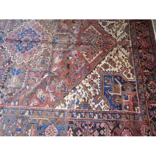 482 - A hand knotted, woollen Heriz rug with red ground, approx. 291cm x 220cm, in good condition