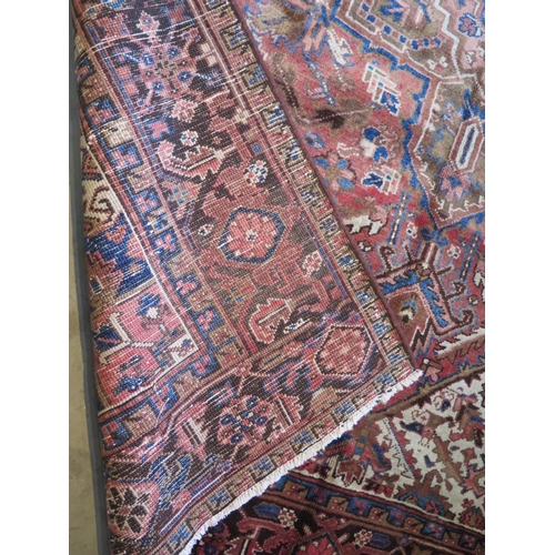 482 - A hand knotted, woollen Heriz rug with red ground, approx. 291cm x 220cm, in good condition