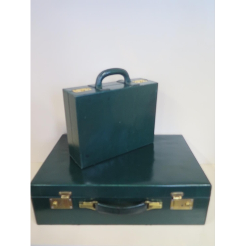 607 - A good quality green leather travel case with a fitted inner case having two silver brushes, three b... 