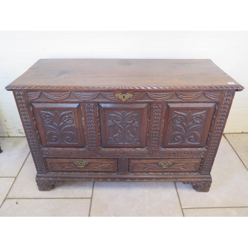 165 - An 18th Century oak mule chest with a carved three panel front and two drawers, standing on bracket ... 