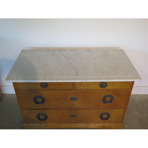 172 - An Arts and Crafts marble top oak chest, with two short over two long drawers, with stylised hammere... 