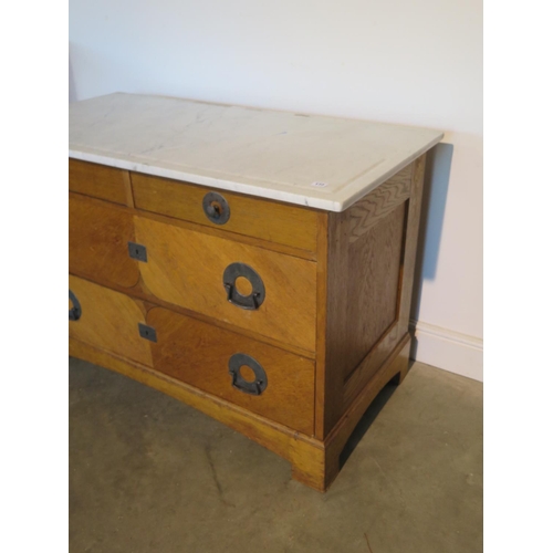 172 - An Arts and Crafts marble top oak chest, with two short over two long drawers, with stylised hammere... 