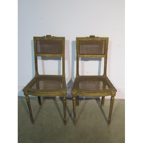 197 - A pair of gilt side chairs with cane seats and backs, caning good to one chair, slight wear to other