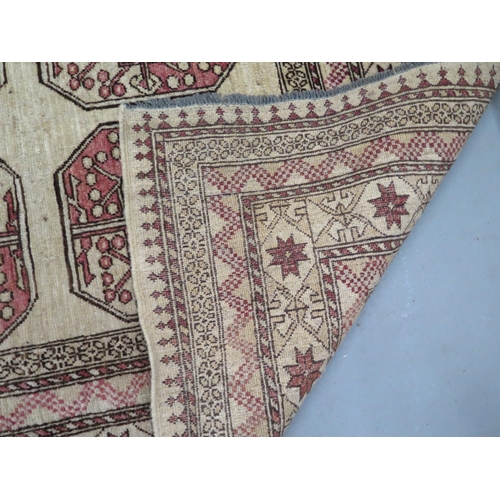 455 - A woollen cream ground rug, decorated with geometric shapes, approx 300cm x 203cm - in decent genera... 