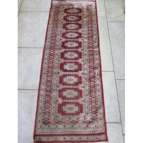 489 - A hand knotted woollen runner 195cm x 66cm - colours bright some small usage wear mainly to fringes