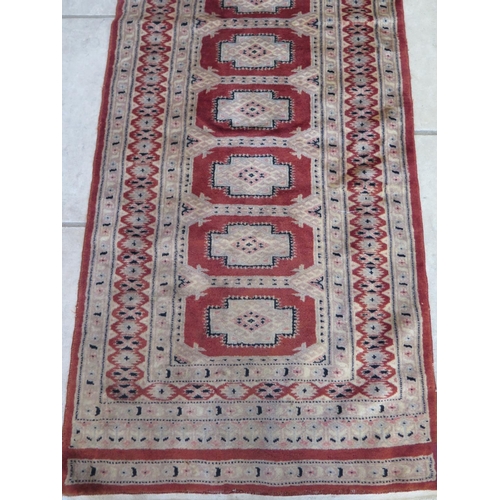 489 - A hand knotted woollen runner 195cm x 66cm - colours bright some small usage wear mainly to fringes