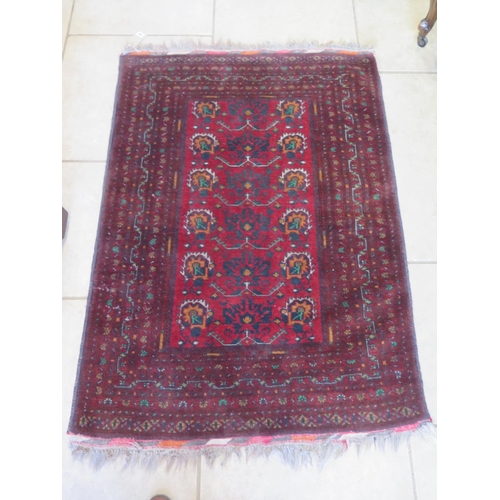 490 - A hand knotted woollen rug with a red field - 158cm x 105cm - colours good, some small wear mainly t... 