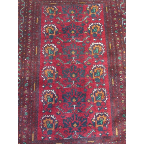 490 - A hand knotted woollen rug with a red field - 158cm x 105cm - colours good, some small wear mainly t... 