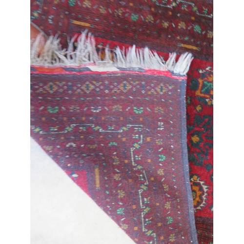 490 - A hand knotted woollen rug with a red field - 158cm x 105cm - colours good, some small wear mainly t... 