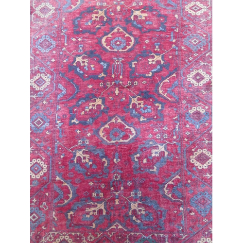 491 - A hand knotted woollen rug with a red field - 137cm x 84cm - some usage wear mainly to edges but no ... 