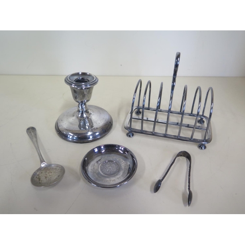 582 - Five pieces of silver, a toast rack, spoon, coin dish, nips and a weighted candlestick - total weigh... 