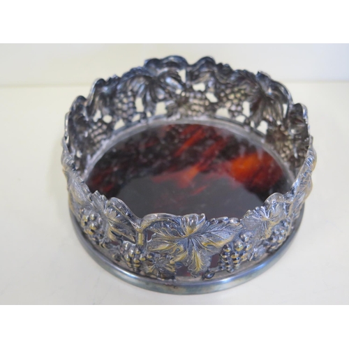 602 - A silver plated grape and vine plated wine coaster with tortoiseshell base, 14cm diameter, stand wel... 