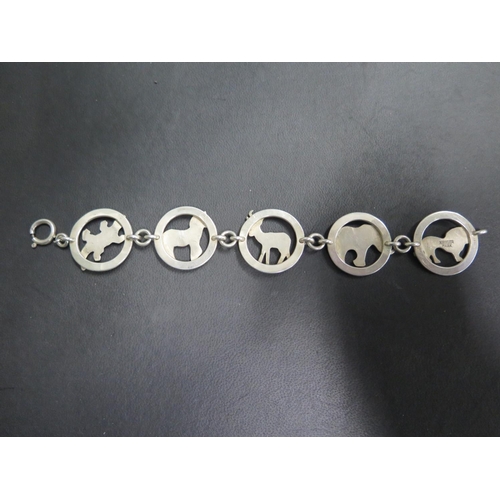 655 - A South African Krugar Park silver bracelet, made up of panels depicting different wild animals, mak... 