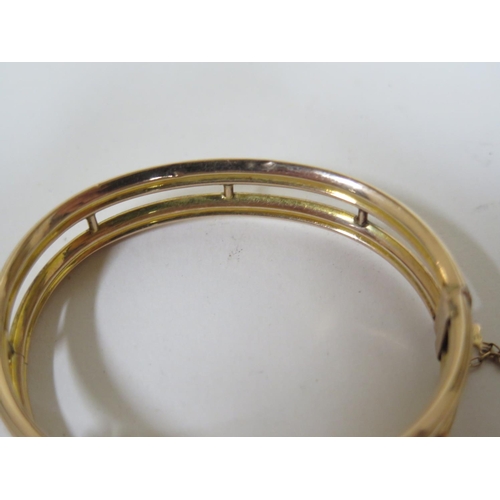 657 - A 9ct gold bangle with diamonds, a sapphire and three blue stones, approx 11.3 grams, approx 6.5cm o... 