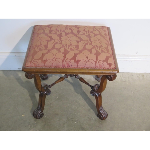 254 - A Victorian walnut upholstered stool on scroll supports, united by turned stretchers, some signs of ... 