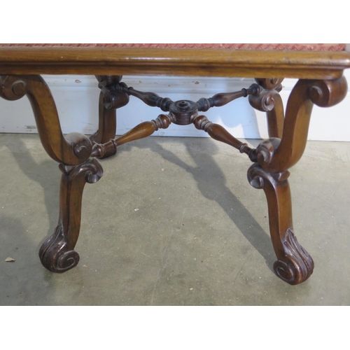 254 - A Victorian walnut upholstered stool on scroll supports, united by turned stretchers, some signs of ... 